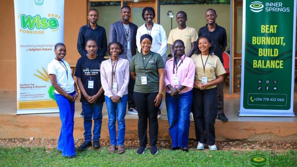 Workshop participants and facilitators smiling together in front of InnerSprings banners